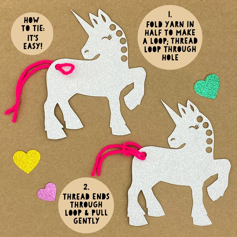 May include: Two white glitter unicorn shapes with pink yarn tails. Instructions for tying the yarn tails are included: "1. Fold yarn in half to make a loop; thread loop through hole" and "2. Thread ends through loop & pull gently".