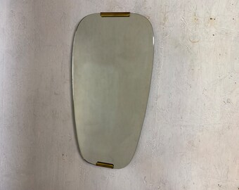 Kidney-shaped mirror with brass applications