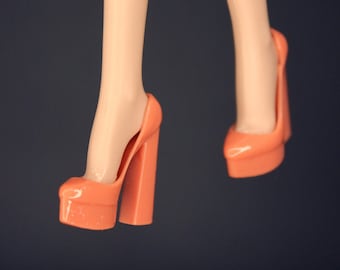 Puede incluir: Un par de tacones de plataforma de color coral con un tacón alto y una punta cerrada.