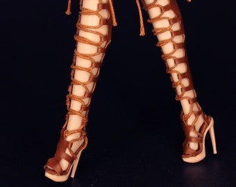 Puede incluir: Botas de cuero marrón con cordones y tacones altos. Las botas tienen un estilo gladiador con correas que suben por la pierna.