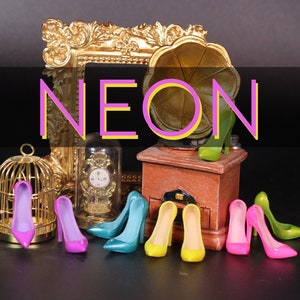Puede incluir: Una colección de zapatos de tacón alto de colores en rosa, morado, azul, verde y amarillo. Los zapatos están dispuestos en una fila sobre una superficie negra. La palabra "NEON" está escrita en letras rosa y amarillo sobre un fondo negro.