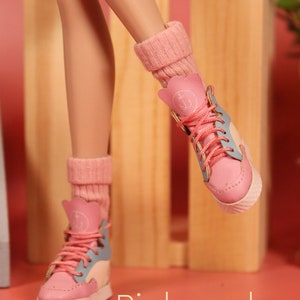May include: A pair of pink socks with white trim and an anchor design. The socks are worn with blue and pink high-top sneakers.