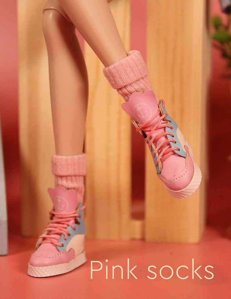 May include: A pair of pink socks with white trim and an anchor design. The socks are worn with blue and pink high-top sneakers.