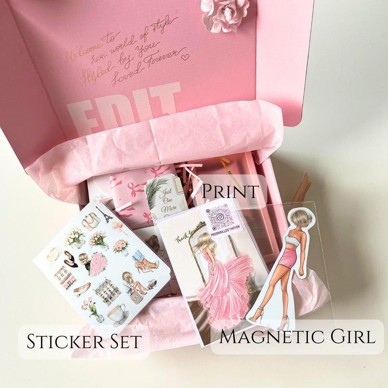 May include: A pink box with a sticker set, a print of a woman in a pink dress, and a magnetic girl sticker. The box is open and the items are visible inside. The box has the text "Welcome to her world of style Styled by you Loved Forever" on the top.