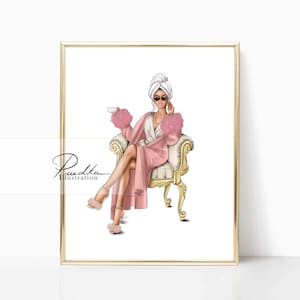 May include: A woman in a pink robe and white towel sits on a gold chair with a cup in her hand. She is wearing sunglasses and has a relaxed expression.