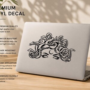 May include: Black vinyl decal of Medusa on a laptop. The decal is water-resistant, fade-resistant, and has a strong adhesive. Text on the image reads "PREMIUM VINYL DECAL".