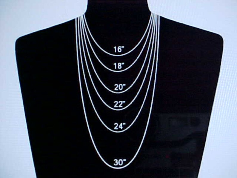 May include: A black mannequin wearing a silver chain necklace with different lengths marked in inches: 16, 18, 20, 22, 24, and 30 inches.