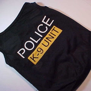 May include: Black dog vest with white "POLICE K-9 UNIT" text on a yellow background.