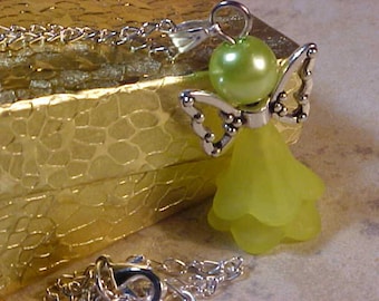 May include: A silver charm necklace with a green angel pendant. The angel has a green glass bead for a head and silver wings.