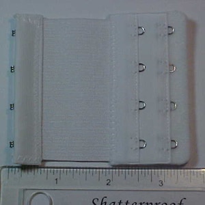 May include: White bra extender with four rows of hooks and eyes. The extender is approximately 3 inches long.