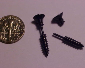 May include: Three black screw-shaped earrings with a flat top. The earrings are about the size of a dime.