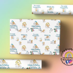 May include: White wrapping paper with a repeating pattern of cartoon babies, clouds, and the text "Happy Birthday Jarmaine" and "ONEder Boy Jarmaine" in blue. Rolls of the same paper are also visible.