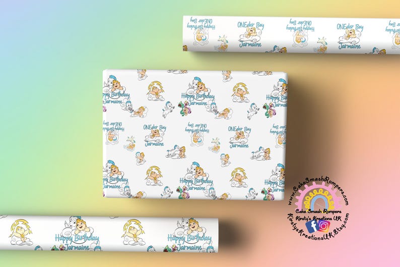 May include: White wrapping paper with a repeating pattern of cartoon babies, clouds, and the text "Happy Birthday Jarmaine" and "ONEder Boy Jarmaine" in blue. Rolls of the same paper are also visible.