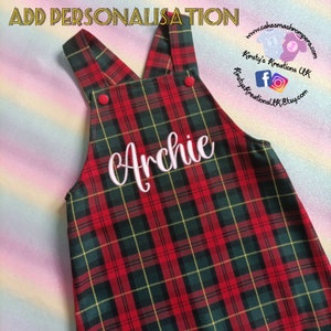 May include: Red and green tartan dungarees with the name "Archie" embroidered in white on the front.