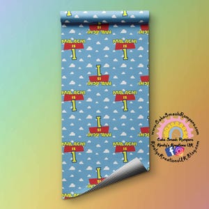 May include: A blue and white patterned wrapping paper with a red and yellow sign that says "Malachi is 1". The sign is repeated throughout the pattern.