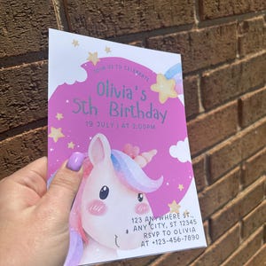 Może przedstawiać: R&oacute;żowe i białe zaproszenie urodzinowe z ilustracją jednorożca. Na zaproszeniu widnieje napis "Olivia's 5th Birthday" z datą i godziną. Zawiera r&oacute;wnież adres i informacje RSVP.