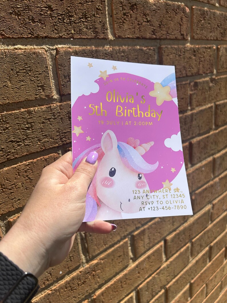 Może przedstawiać: R&oacute;żowo-białe zaproszenie urodzinowe z ilustracją jednorożca. Na zaproszeniu widnieje napis "Olivia's 5th Birthday" z datą i godziną. Zawiera r&oacute;wnież adres i informacje RSVP.