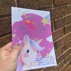 Może przedstawiać: R&oacute;żowo-białe zaproszenie urodzinowe z ilustracją jednorożca. Zaproszenie zawiera tekst "Olivia's 5th Birthday" z datą i godziną. Dodatkowy tekst zawiera adres i informacje RSVP.