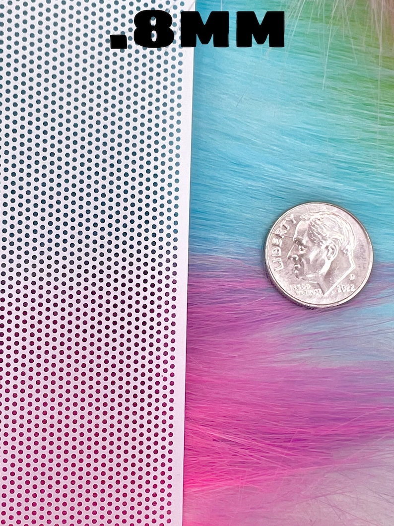 May include: A white sheet of perforated plastic with 0.8 mm holes, next to a strand of multi-colored synthetic hair with a US dime for scale.