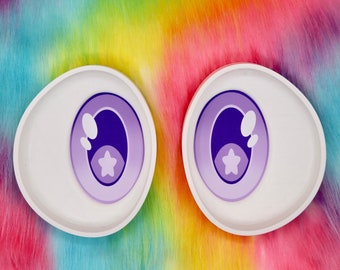 May include: Two white, oval-shaped eyes with purple irises and star details. The eyes are set against a vibrant, rainbow-colored background. Text at the top reads "EYE MESH SOLD SEPARATELY".