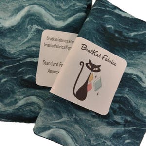 May include: A set of three ceramic mugs with a speckled, matte finish. The mugs are in shades of cream, light gray, and dark gray. Each mug has a simple, minimalist design, perfect for coffee or tea.