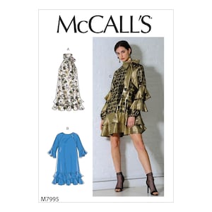 May include: A McCall's sewing pattern featuring three dress designs. One dress is a gold and black metallic mini dress with ruffled sleeves and hem. Another is a blue dress with ruffled hem and sleeves. The third is a floral print dress with a bow.
