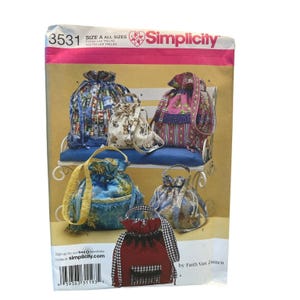 May include: Simplicity sewing pattern 3531 featuring various drawstring bag designs. The bags showcase diverse fabrics and styles, including floral, patterned, and solid colors. The pattern includes the text "SIZE A ALL SIZES" and "Simplicity".
