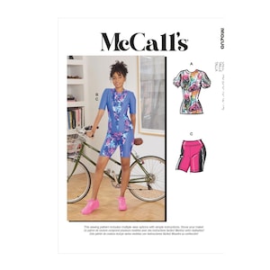 May include: McCall's sewing pattern featuring a woman in a blue floral print cycling outfit. The pattern includes options for a top and shorts. The McCall's logo is at the top, with text in English and Spanish.