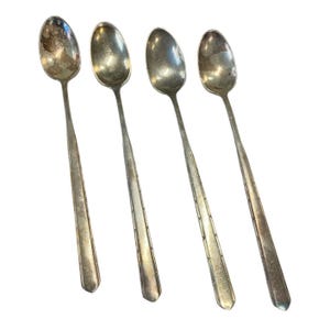 Puede incluir: Juego de cuatro cucharaditas de plata con un diseño simple y elegante. Las cucharas tienen un cuenco redondeado y un mango largo y delgado.