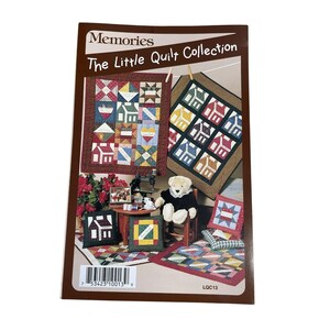 May include: A book cover titled "Memories The Little Quilt Collection" showing images of miniature quilts with house and geometric patterns. The cover has a brown border and includes a barcode and the text "LQC13".