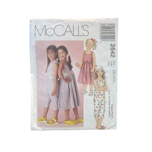 Peut inclure: Pochette de patron de couture McCall's 2642 pour vêtements d'enfant, taille 4-5-6. Le devant présente des illustrations d'enfants portant une combinaison rayée, une robe plissée, une robe vichy rouge et un haut à fleurs avec pantalon assorti.