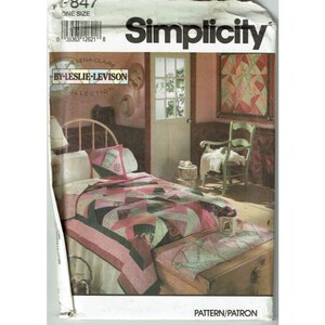 May include: Simplicity sewing pattern 1847, by Leslie Levison, for a quilt with a starburst design. The pattern shows a bedroom with a bed, a chair, and a quilt on the bed.