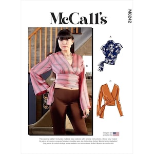 May include: McCall's sewing pattern M8242 featuring a woman wearing a pink striped wrap top. The pattern includes multiple view options with simple instructions. Designed and printed in the USA.