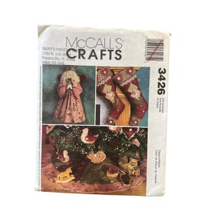 May include: A McCall's Crafts pattern envelope featuring images of Christmas stockings, an angel doll, and tree ornaments. The envelope has the text "McCall's Crafts" and "3426" printed on it.