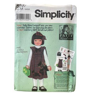 May include: Simplicity sewing pattern with a girl in a plaid dress. The pattern includes a free matching paper doll. The package has the text "New! Patty Reed Designs lets you sew adorable clothes for your child".