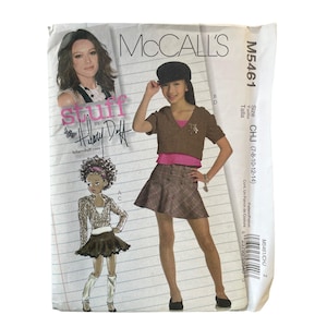 May include: A McCall's sewing pattern featuring a design by Hilary Duff. The pattern includes illustrations of a young girl wearing a brown and pink outfit and a plaid skirt. The pattern size is CHJ (7-8-10-12-14).