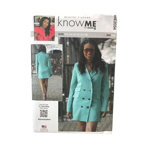 May include: A sewing pattern package featuring a teal double-breasted blazer dress. The package includes images of the garment and the text "knowME by mimi g". The size range is Y5 (18-20-22-24-26). The package also includes a QR code for a sew-along video tutorial.
