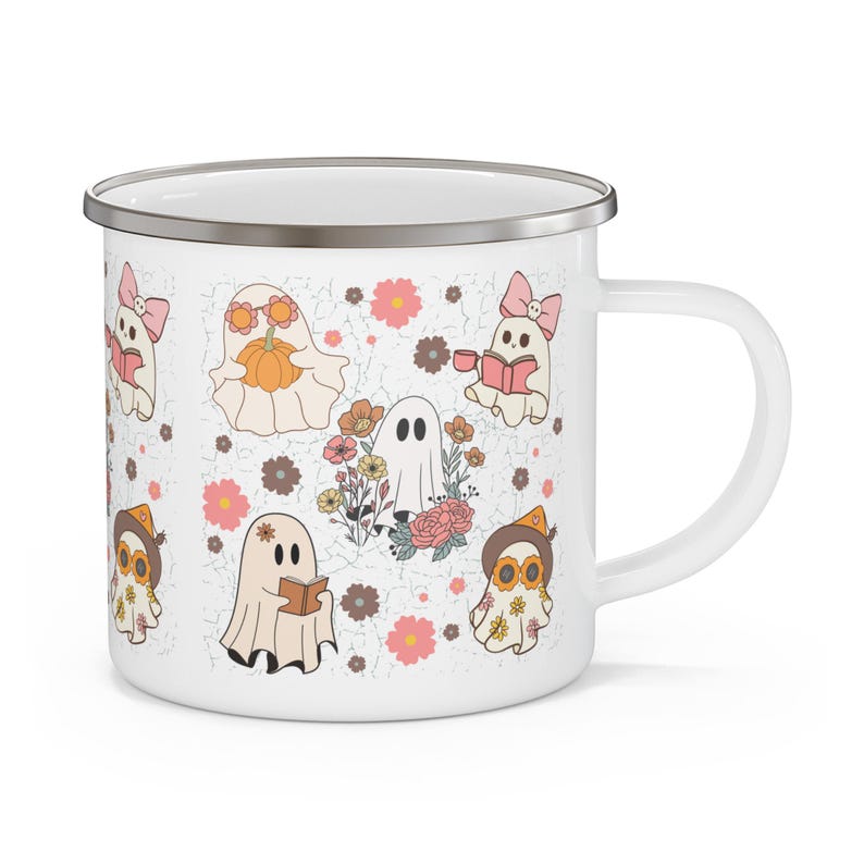 May include: A white enamel mug with a silver rim featuring a repeating pattern of cartoon ghosts, flowers, and books. The ghosts are depicted in various activities, including reading books, holding a pumpkin, and wearing hats or bows in soft pastel colors.