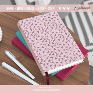 May include: A stack of three notebooks with pink, teal, and burgundy covers. The top notebook has a pink cover with a repeating pattern of small pink hearts and dots. The text "SVG - EPS - PNG - JPG - DXF" is at the top of the image. The text "MORE SVG FILES AT ETSY.COM/AU/SHOP/SANDRAHERRGOTT" is at the bottom of the image.