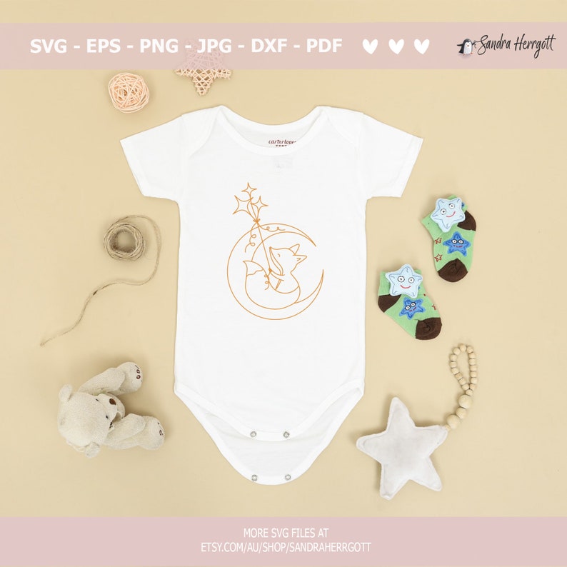 May include: A white baby onesie with a line drawing of a fox holding a star on a crescent moon. The onesie is surrounded by a teddy bear, a star, and a string of wooden beads.