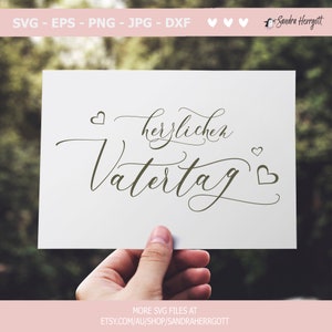 May include: A white card with the text "herzlichen Vatertag" written in cursive script with two small hearts on either side of the text.