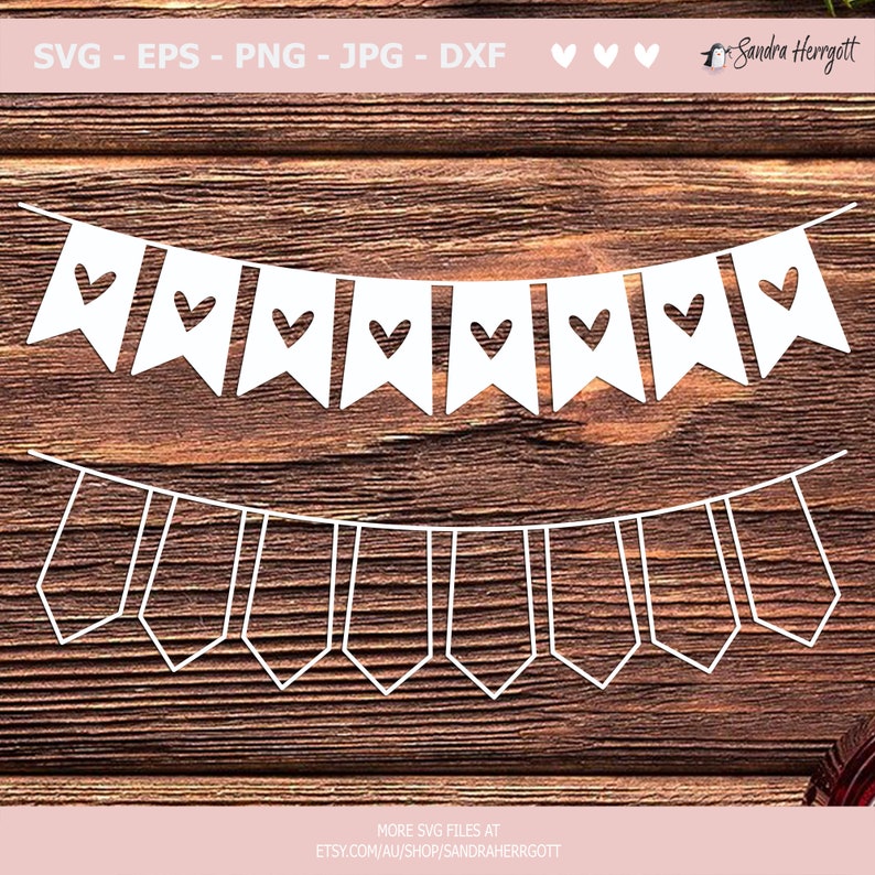 May include: White paper banner with a repeating pattern of flags with a heart cut-out. The banner is hanging from a string of small white triangles. The banner is on a brown wooden background.
