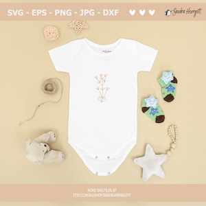 May include: A white baby onesie with a simple line drawing of a plant with leaves and flowers in brown. The onesie is surrounded by various baby items, including a stuffed bear, a star-shaped rattle, and a pair of socks with star designs.