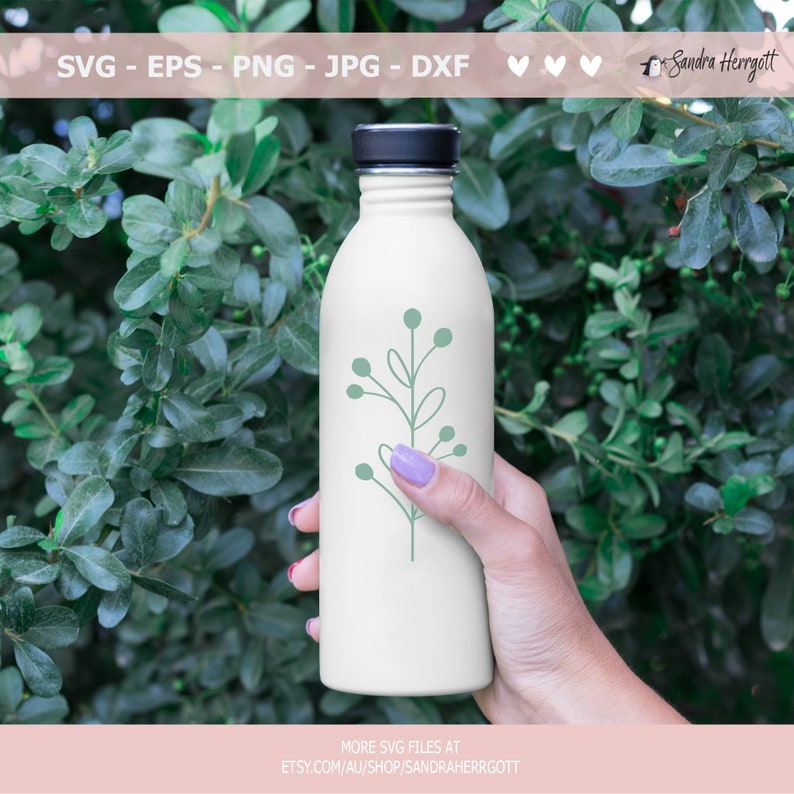 May include: A white water bottle with a green leafy branch design. The bottle is being held by a hand.