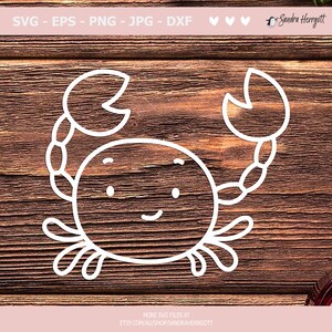 May include: A white outline drawing of a cartoon crab with a smiling face on a brown wooden background.