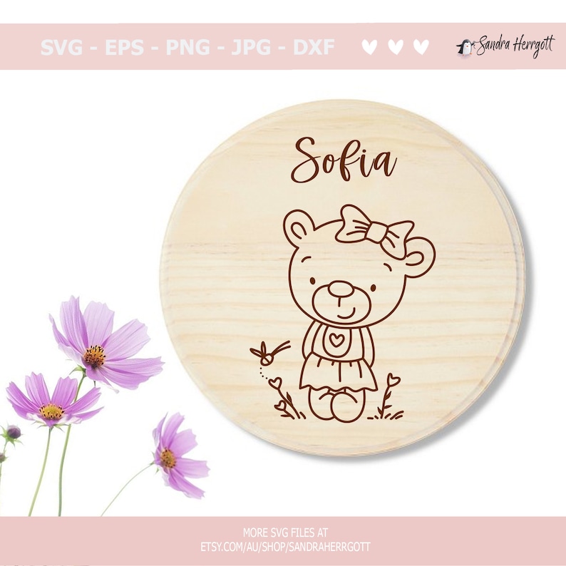 May include: A wooden round sign with the name "Sofia" written in cursive. A line drawing of a teddy bear wearing a dress and a bow is in the center of the sign.