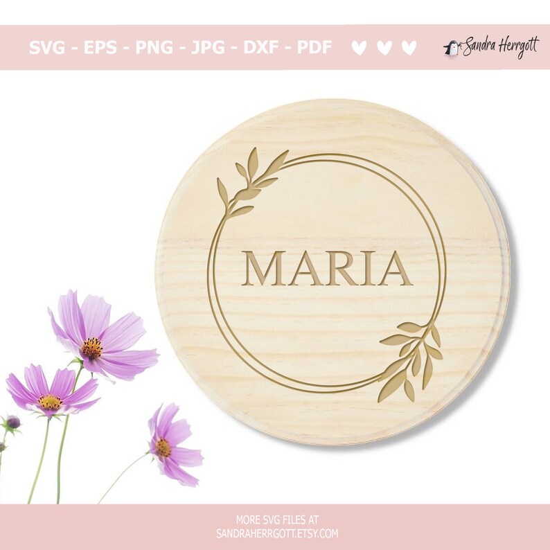 May include: A round wooden sign with a gold circle and floral design. The name "MARIA" is written in gold lettering inside the circle.