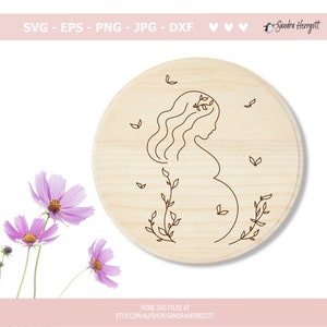 Pu&ograve; includere: Un disegno a linea di una donna incinta con una corona di fiori e foglie intorno a lei. Il disegno &egrave; su una placca rotonda di legno.