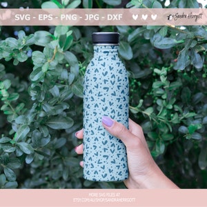 May include: A light blue reusable water bottle with a black lid and a pattern of blue hearts and dots. The bottle is being held by a hand.