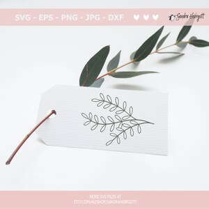 May include: A simple black and white line drawing of a leafy branch on a white tag. The tag is attached to a green eucalyptus branch.